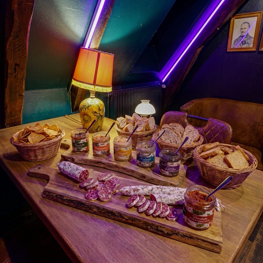 Planche Grignotage++ dressée au Braz : saucissons secs entiers et tranchés, rangée de bocaux de tartinables, pains et chips